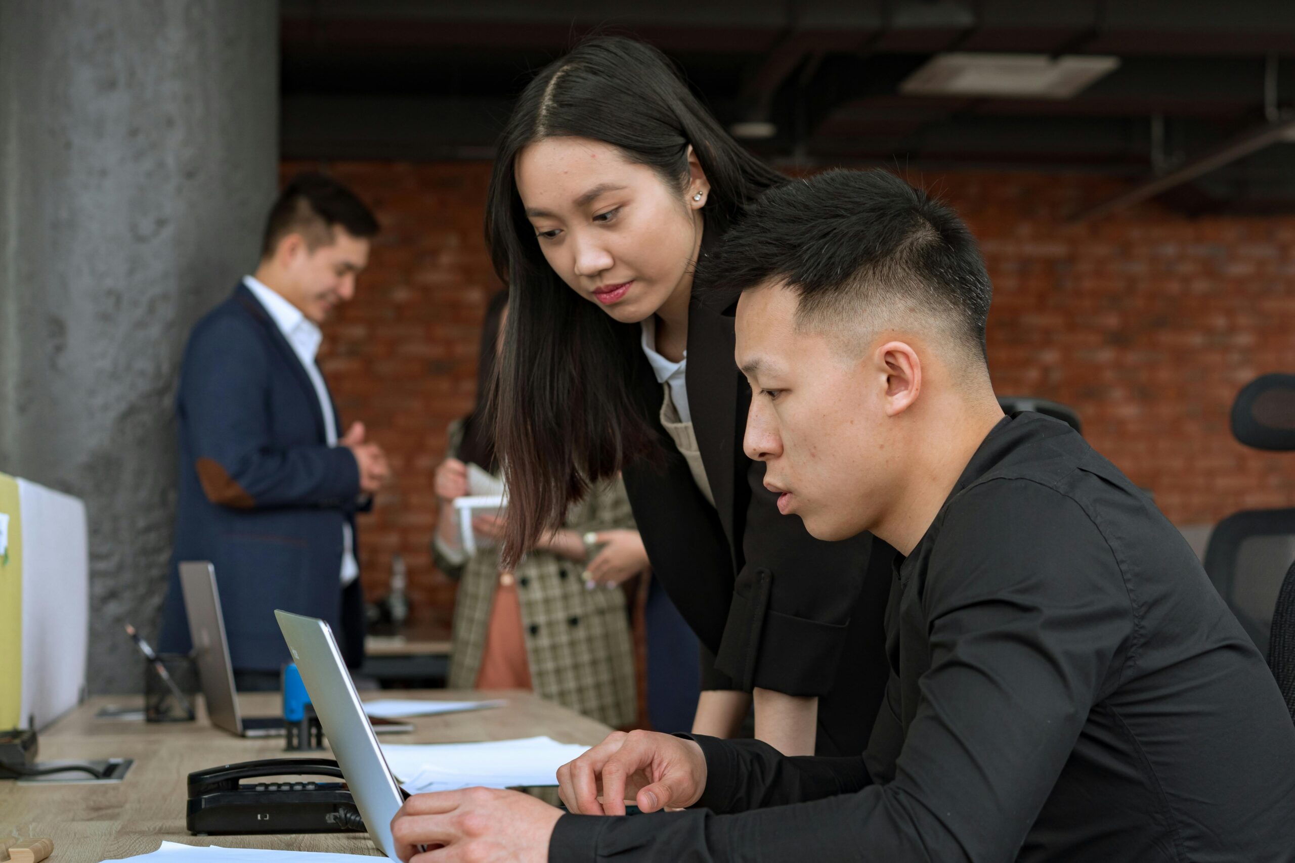 man and woman looking at financial reports on a laptop together