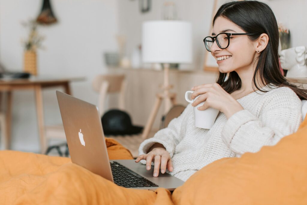 Woman smiling while drinking coffee and working