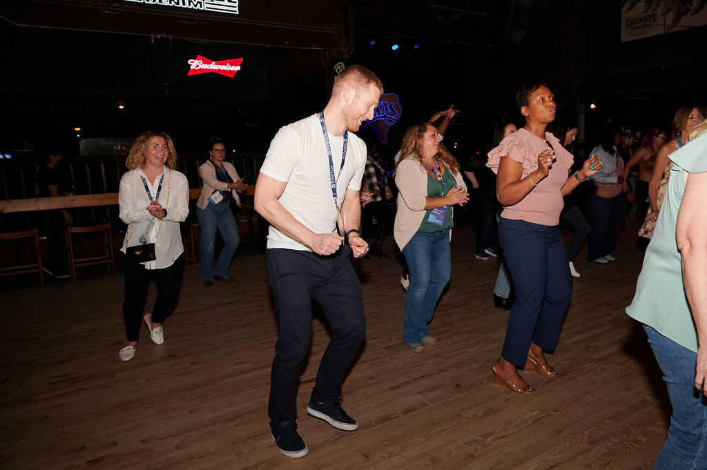 People line dancing at Billy Bob's Honkytonk in Fort Worth, TX, part of Trintech's customer awards celebration